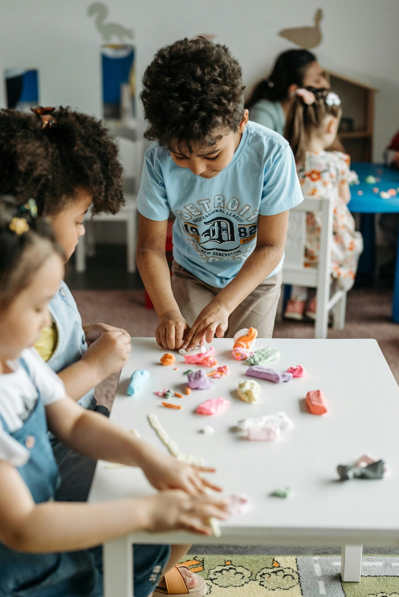 Young kids enjoy crafting with colorful clay in a playful, creative classroom setting.